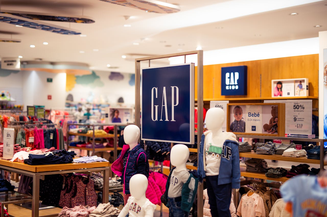 Explore the colorful and trendy children's clothing section in a modern retail store with mannequins and promotional signage.