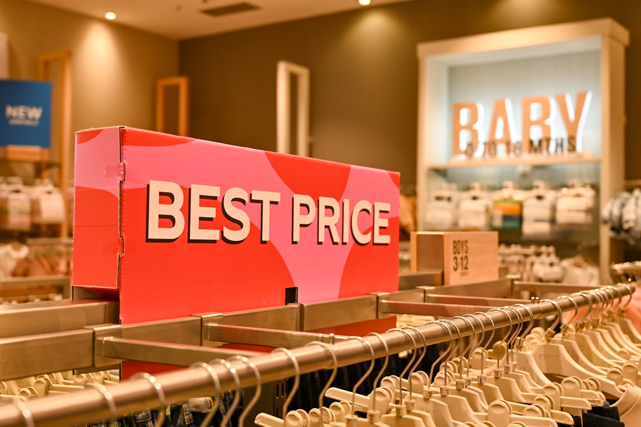 Image of a baby clothing store interior with a prominent 'Best Price' sign on display rack.